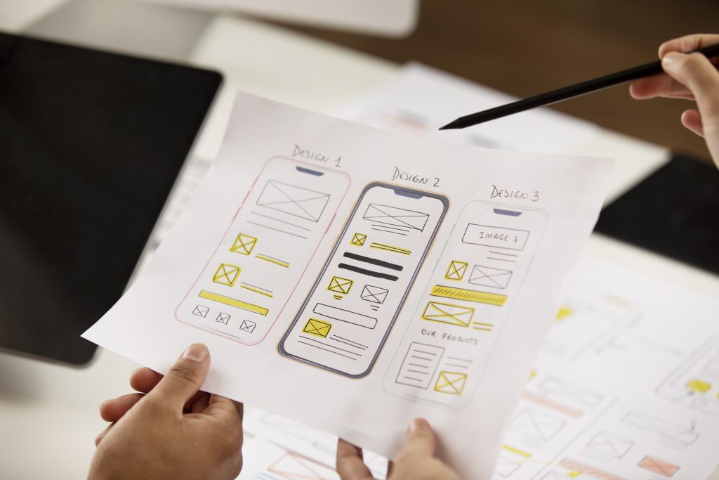 Ομάδα σχεδιαστών δουλεύει σε wireframes και UI mockups για βελτιστοποίηση εμπειρίας χρήστη
